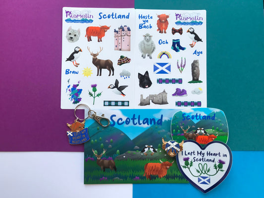 Scotland themed gift bundle which includes an enamel pin and keychain postcard, sticker sheets, vinyl stickers.